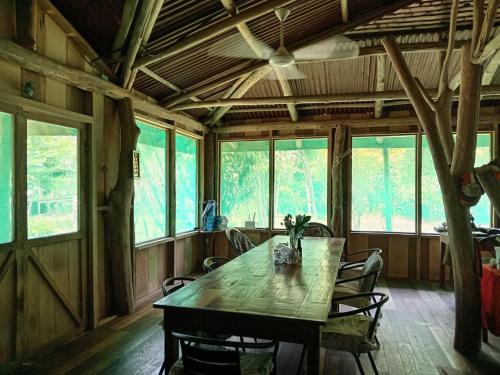 Siquirres的住宿－ESMERALDA LODGE，一间带木桌和椅子的用餐室