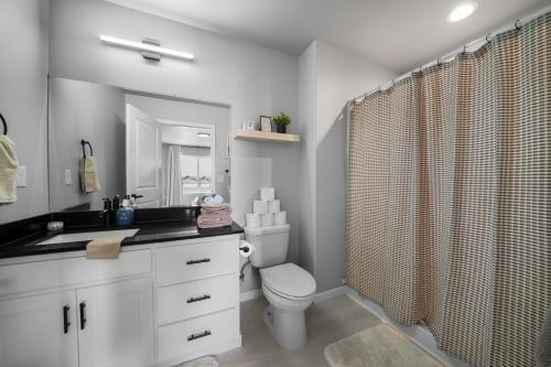 a bathroom with a toilet and a shower curtain at Contemporary Comfort in Quincy in Quincy