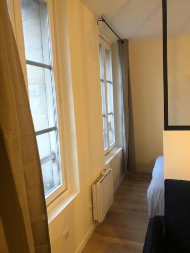 um quarto com duas janelas e uma cama nele em Le Charles III : Élégance et Sérénité em Nancy