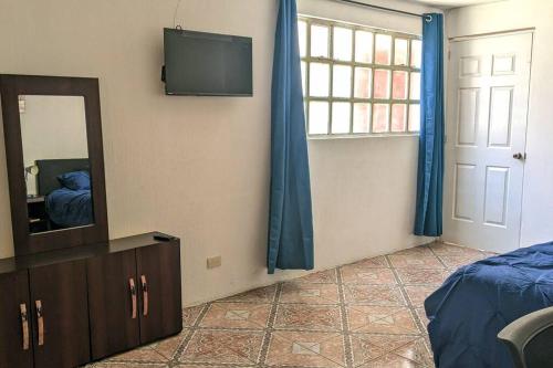 a bedroom with a mirror and a television on the wall at Apartment in Colonia Molina in Quetzaltenango