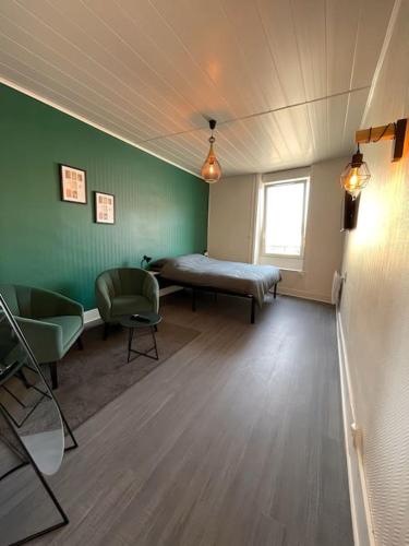 Habitación con cama, 2 sillas y ventana en T2 splendide, 3 min gare Mulsant, en Roanne