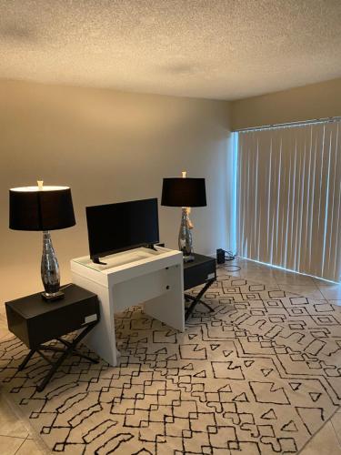 - un salon avec un bureau et deux lampes dans l'établissement Presidential Golfview Condominiums, à West Palm Beach