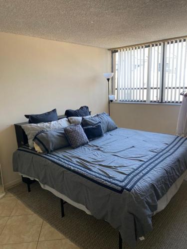 - une chambre avec un lit doté de draps et d'oreillers bleus dans l'établissement Presidential Golfview Condominiums, à West Palm Beach