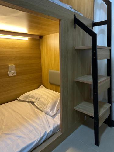 een stapelbed met een stapelladder naast een bed bij Waveflo Hostel 浪花青旅 in Hong Kong