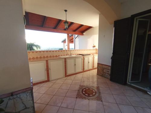 a kitchen with a large window and a tile floor at Villa Framaca in Furnari