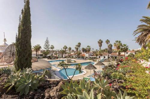 a resort with a swimming pool and palm trees at La Vista Preciosa in San Miguel de Abona