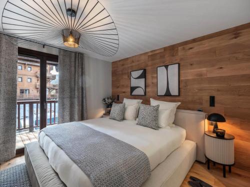 a bedroom with a large bed and a large window at Résidence Goyard - Chalets pour 12 Personnes 184 in Courchevel