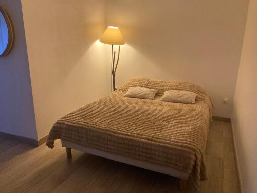 - une chambre avec un lit et une lampe dans l'établissement Grand Studio Nice terrasse et piscine, à Nice