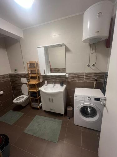 a bathroom with a sink and a washing machine at Una-No1 in Bihać