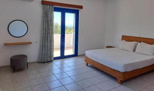a bedroom with a bed and a mirror and a window at Melissa Apartments in Frangokastello