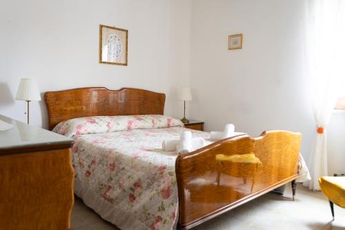 Un dormitorio con una cama con cabecero de madera. en Casa di Nonna Linda, en Portocannone