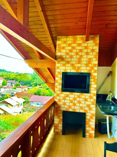 a balcony with a tv on a brick wall at Apartamento Bierbaum in Treze Tílias