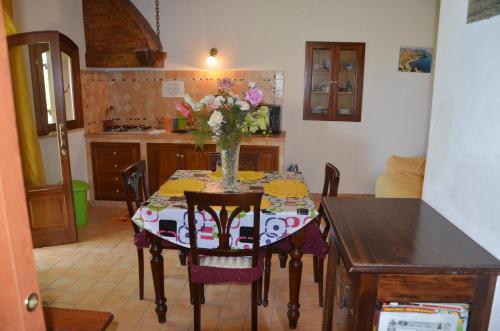 une cuisine avec une table et un vase de fleurs. dans l'établissement Guest House Belvedere, à Tropea