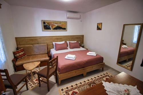 a small bedroom with a bed and a mirror at Emblematic House Apartment 4 in Gjirokastër