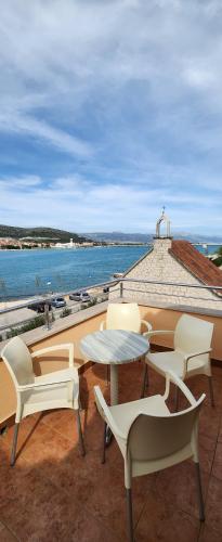 un patio con tavolo, sedie e vista sull'oceano di Apartments Kapetanovi Dvori a Trogir