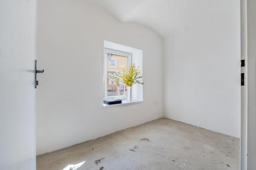 an empty room with a window and a cross at Apartmány Rozárka Turnov in Turnov