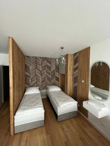 1 dormitorio con 2 camas y lámpara de araña en ANETT, en Sulęcin
