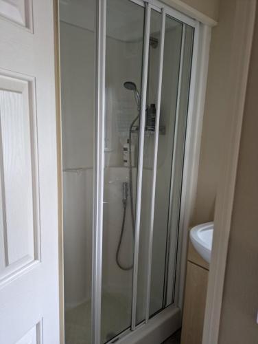 uma casa de banho com um chuveiro e um lavatório. em luxury home from home caravan em Ingoldmells