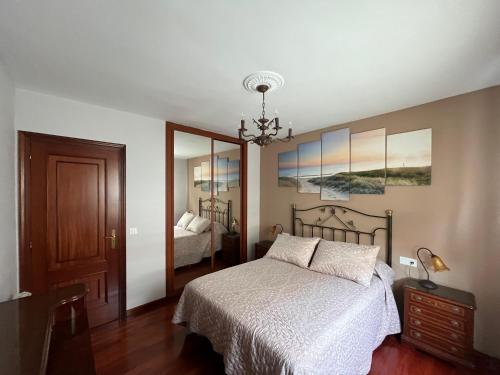 a bedroom with a bed and a mirror at Alquiler Vacacional en Ribeira in Ribeira