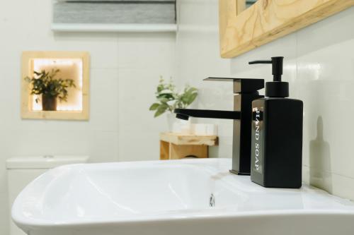 a black soap dispenser sitting on top of a sink at Kashco Apartments Wuse 2 Abuja in Abuja