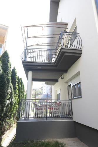 a balcony with tables and chairs on a building at Kuća JEKA in Vrnjačka Banja