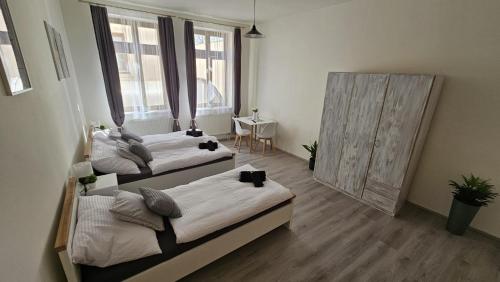 two beds in a room with a mirror at Penzion Grand Nymburk in Nymburk