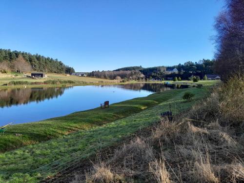 a view of a river from a field at The Lakeside Cabin in Longmorn