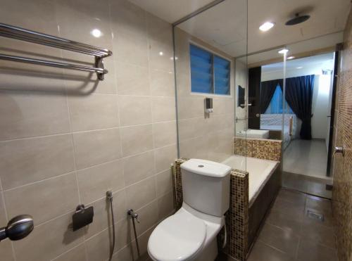 a bathroom with a toilet and a sink and a mirror at Marina Island Lumut HomeHotel in Lumut