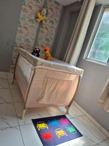 a crib with two stuffed animals sitting on top of it at SUA CASA EM GARANHUNS Aptº INTEIRO COM 04 QUARTOS in Garanhuns