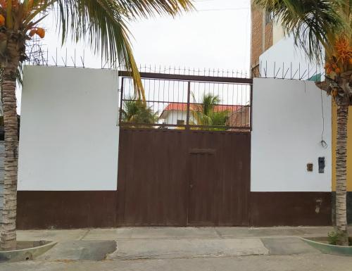 パカズマヨにあるLa Arteza Pacasmayoの椰子の木の門の看板2枚