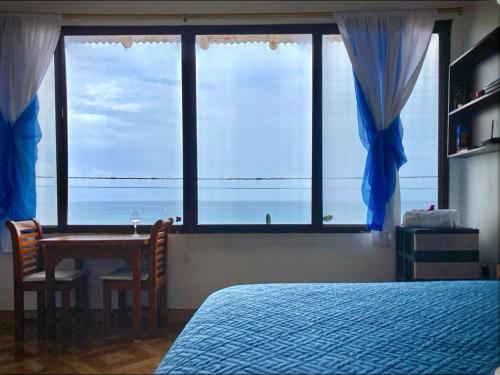 een slaapkamer met een bed en een tafel met uitzicht op de oceaan bij Suite frente al mar - CIELO in Montañita