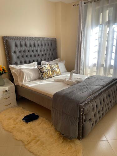 1 dormitorio con 1 cama grande y cabecero de metal en Executive Cozy Furnished Apartment-In Utawala, NBO, Near JKIA, en Nairobi