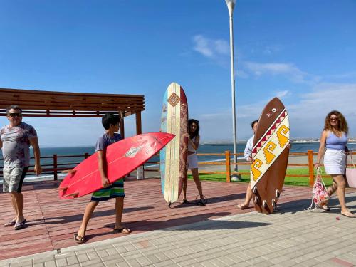 een groep mensen met surfplanken op een promenade bij Family Surf Chicama in Puerto Chicama