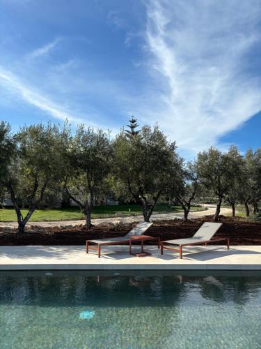 two chairs sitting next to a swimming pool at Villa Narducci in Montalbano