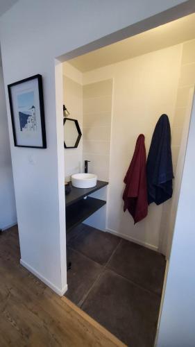 une salle de bain avec un lavabo et des toilettes dans une chambre dans l'établissement Maison proche du centre, à Auray
