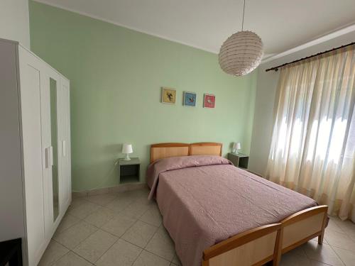a bedroom with a bed with a purple bedspread at Il Poggio del Cilento Country House in Agropoli