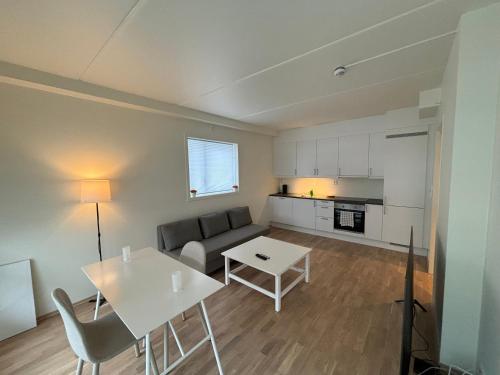 een woonkamer met een bank en een tafel bij New Modern Apartment in Central Jessheim in Jessheim