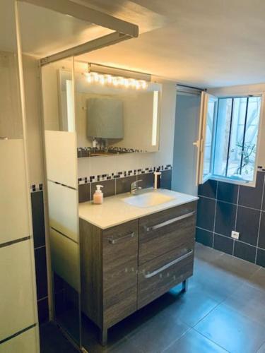 une salle de bain avec un lavabo et un miroir dans l'établissement Appart proche Paris, Disneyland+la Vallée Village., à Villiers-sur-Marne