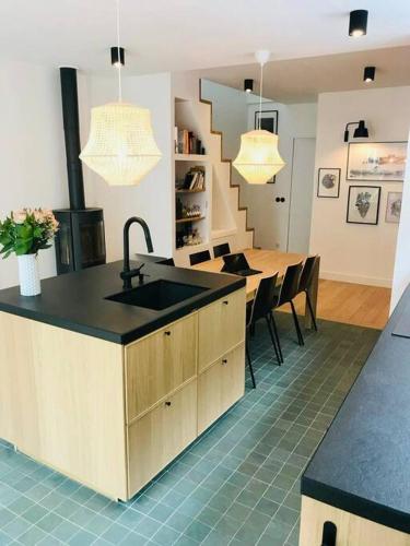 une cuisine avec un évier et une table avec des chaises dans l'établissement Maison lumineuse de 100m2 avec jardin et parking., à Nanterre