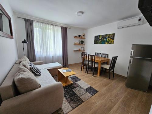 a living room with a couch and a table at Apartments Woodnotes in Ličko Petrovo Selo