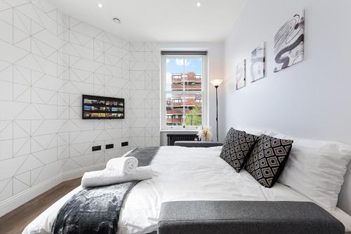 um quarto com uma grande cama branca e uma janela em Stunning 1 bedroom in Westminster with AC sleeps 4 em Londres