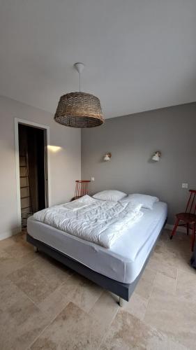 - un grand lit dans une chambre dotée d'un lustre dans l'établissement Maison familiale en version 10 pers. plage à 300 m, à LʼÉpine