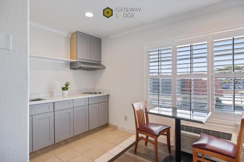 a kitchen with white cabinets and a table and chairs at Gateway Lodge in Seaside