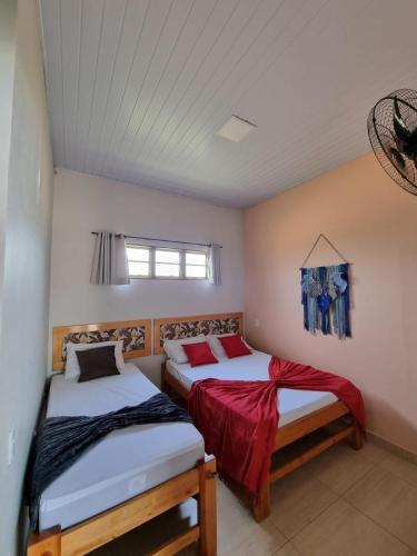 a bedroom with two beds and a window at Pouso da Kakau in Pirenópolis