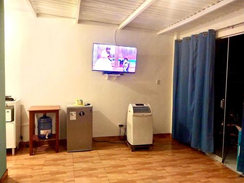 um quarto com uma televisão na parede e uma lata de lixo em Casuarinas del Mar Habitacion Playa em Canoas de Punta Sal