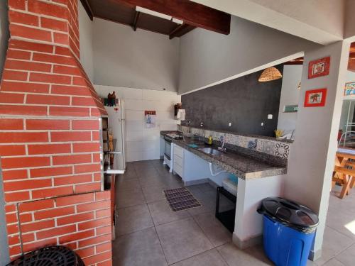 a kitchen with a red brick wall and a counter at Pouso da Kakau in Pirenópolis