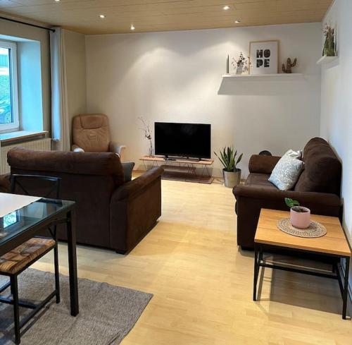a living room with couches and a flat screen tv at Casita grün in Worms