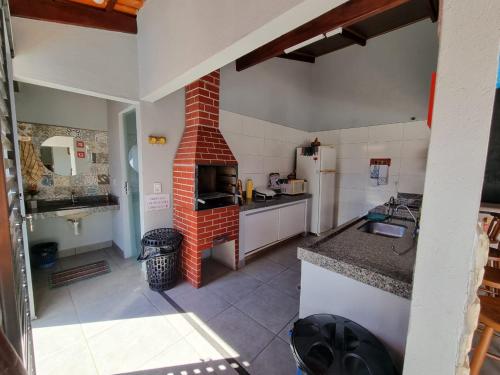 a kitchen with a brick fireplace in a room at Pouso da Kakau in Pirenópolis