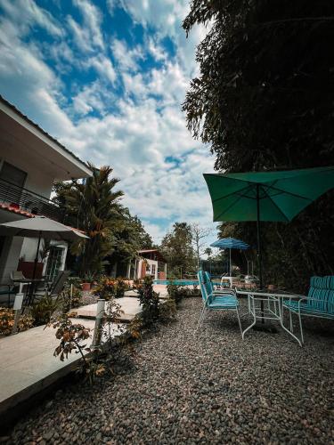 patio con sedie, tavolo e ombrellone di Casa hotel Aeroclubr15 a Villavicencio