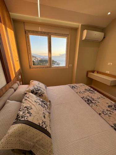 a bedroom with a large bed and a window at Sea Scape Apartment 3 in Vlorë